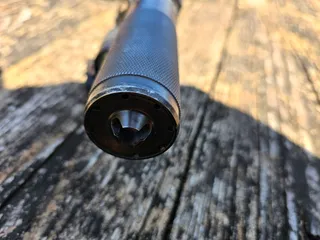 Dead Air R-Series flash hider front cap fitted to a suppressor, viewed head-on into the muzzle, showing the prongs inside the bore